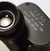 Parameters listed on the prism cover plate describing a 7 power magnification binocular with a 50 mm Objective diameter and a 372-foot (113 m) Field of view at 1,000 yards (1,000 m).